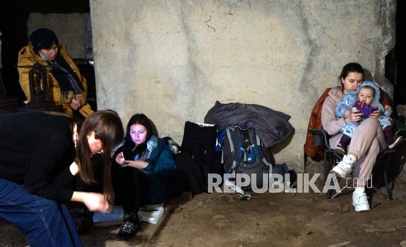 Sejumlah warga berlindung di ruang bawah tanah di apartemen mereka saat terjadi serangan Rusia di kota Karkhiv, Ukraina, Selasa (1/3/2022). Warga Karkhiv memanfaatkan ruangan basement apartemen dan stasiun bawah tanah sebagai tempat berlindung dari serangan misil Rusia. 