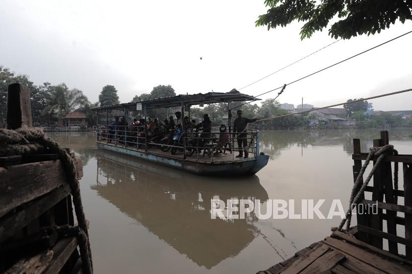 Sejumlah warga bersama kendaraannya berada di atas perahu ketika menyeberangi Sungai Brantas, Surabaya, Jawa Timur, Senin (3/1/2021).(Ilustrasi)
