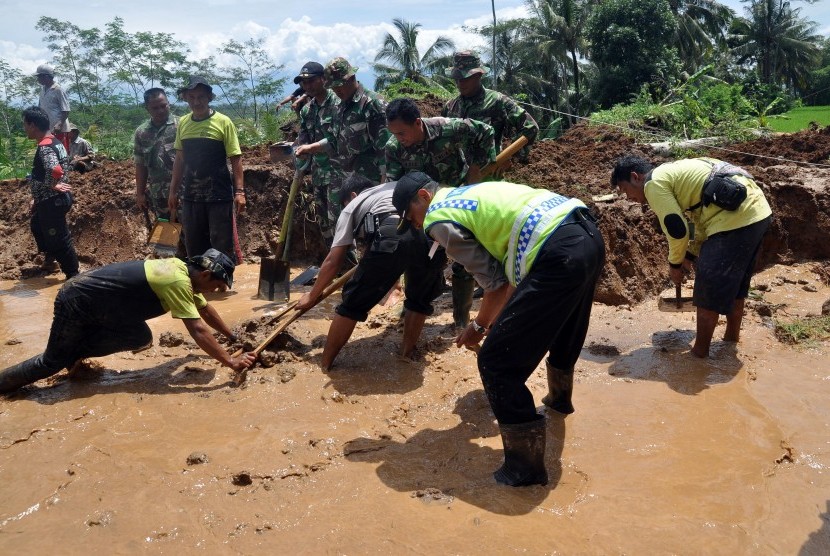 Sejumlah warga bersama tim SAR, anggota TNI dan polisi menyingkirkan timbunan tanah longsor yang menutup jalan antar desa di kawasan lereng gunung Sumbing Desa Kalegen, Bandongan, Magelang, Jawa Tengah, Selasa (15/12). 