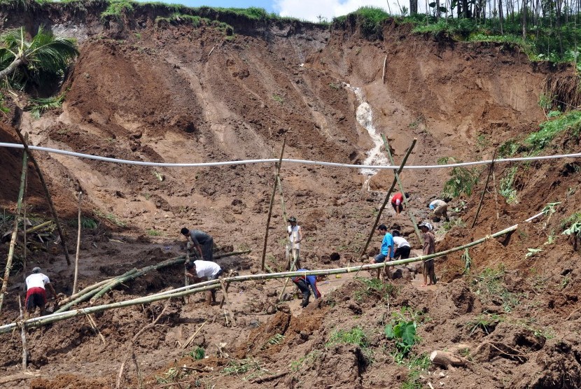 Sejumlah warga bersama tim SAR, anggota TNI dan polisi menyingkirkan timbunan tanah longsor yang menutup jalan antar desa di kawasan lereng gunung Sumbing Desa Kalegen, Bandongan, Magelang, Jawa Tengah, Selasa (15/12).