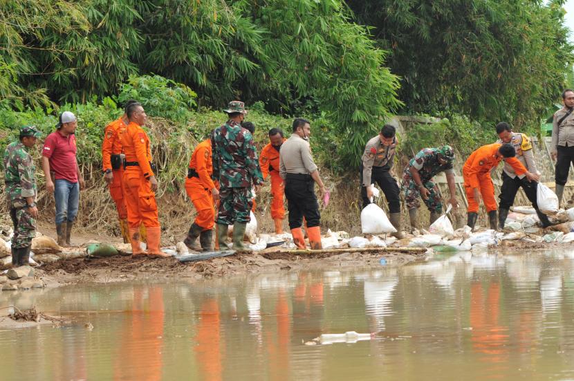 Sejumlah warga bersama TNI, Polri dan BPBD serta relawan memperbaiki tanggul Sungai Suwatu yang jebol di Desa Bulumanis Kidul, Margoyoso, Pati, Jawa Tengah, Jumat (15/7/2022). Perbaikan tanggul sementara sepanjang 30 meter tersebut untuk mencegah banjir susulan setelah pada Kamis 14/7/2022 kawasan tersebut diterjang banjir bandang yang menyebabkan 22 rumah roboh dan hanyut serta ratusan rumah lainnya terdampak. 
