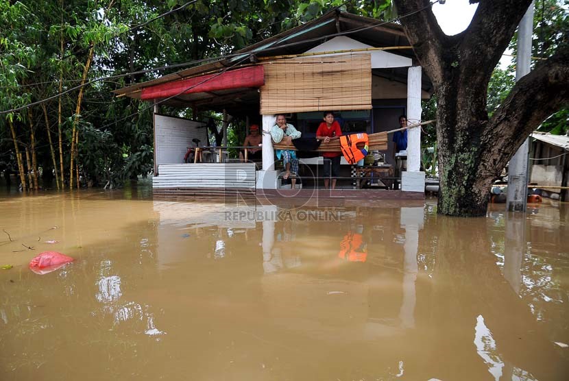  Sejumlah warga bertahan di lantai dua rumahnya yang terendam luapan air Sungai Ciliwung di Jalan H Bawah, Kelurahan Kebon Baru, Kecamatan Tebet, Jakarta Selatan, Rabu (22/1).  (Republika/Prayogi)