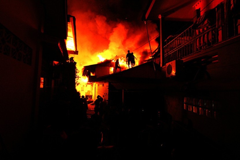 Sejumlah warga berusaha memadamkan api yang menghanguskan kawasan padat penduduk di Jalan Baru Kecamatan Nusaniwe, Ambon Jumat (31/10) malam.