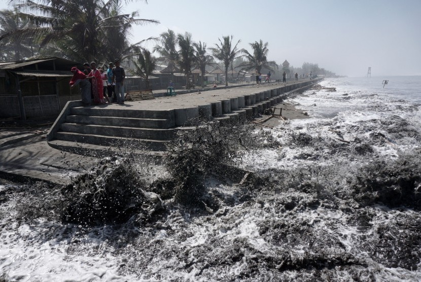 Sejumlah warga berusaha menghindar saat gelombang tinggi menerjang pemecah ombak di Pantai Widarapayung, Binangun, Cilacap, Jateng, Rabu (25/7).