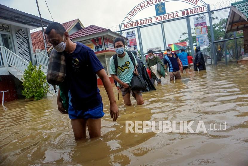 Sejumlah warga binaan membawa barang pribadinya berjalan antre saat evakuasi banjir (ilustrasi)