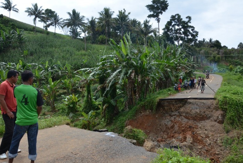 Sejumlah warga dan kendaraan tidak dapat melintas akibat jalan ambles di Desa Puncak Mandiri, Sumalata, Kabupaten Gorontalo Utara, Gorontalo, Sabtu (25/2).