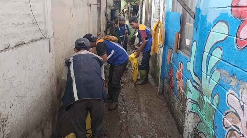Sejumlah warga dan petugas di RW 04 da  RW 08, Kelurahan Braga, Kecamatan Sumur Bandung, Kota Bandung tengah membersihkan rumah dan jalan dari sisa lumpur pascabanjir, Kamis (11/1/2024) kemarin. 