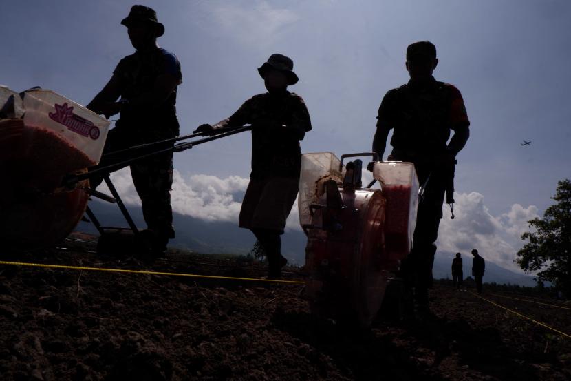 Sejumlah warga dan prajurit TNI menanam jagung menggunakan mesin tanam jagung atau planter di Kampung Kwadewar, Distrik Waibu, Jayapura, Papua, Kamis (28/7/2022). Pulau Maluku dan Papua memberi kontribusi sebesar 2,51 persen terhadap PDB Indonesia, dengan pertumbuhan 13,01 persen (yoy)