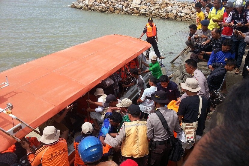 Sejumlah warga dan tim SAR berusaha mengevakuasi salah seorang korban tenggelamnya KM Marina di Pelabuhan Tobaku Kolaka Utara, Sulawesi Tenggara, Minggu (20/12). 