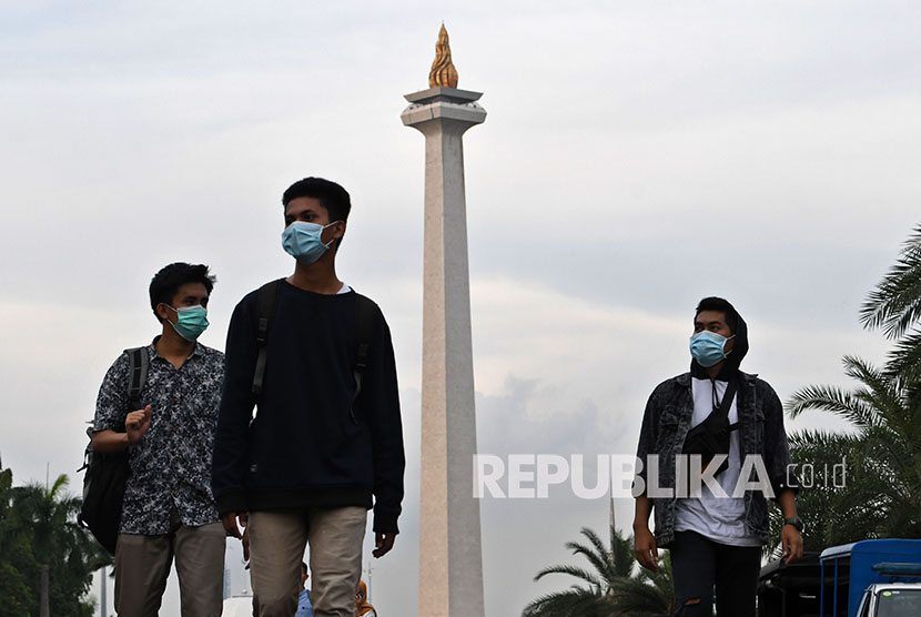 Sejumlah warga dengan menggunakan masker berjalan di kawasan Monumen Nasional, Jakarta, Rabu (11/3/2020).(Republika/Aditya Pradana Putra)
