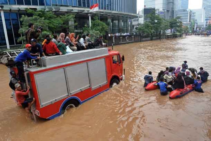  Sejumlah warga dievakuasi dengan menggunakan perahu karet dan mobil pemadam kebakaran ketika banjir melanda kawasan Jl. Sudirman, Jakarta, Kamis (17/1).