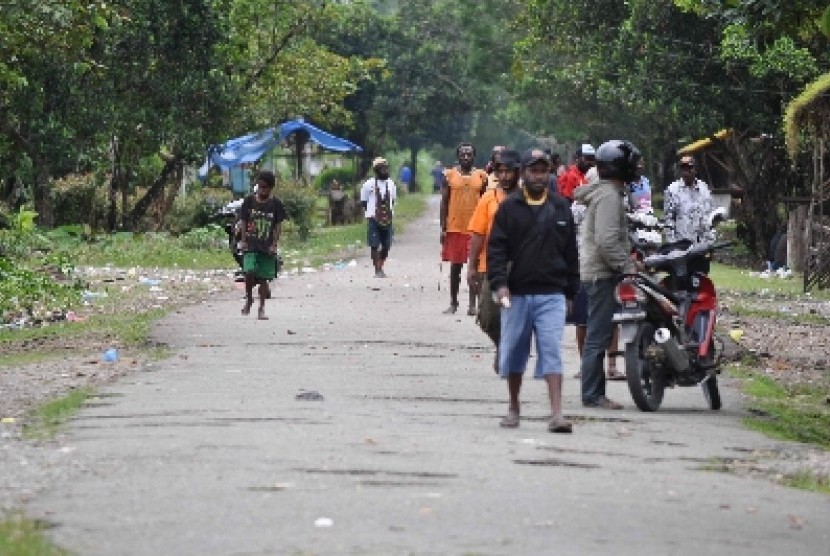  Sejumlah warga duduk dan berjalan di lokasi pertikaian dua kelompok warga di Kwamki Lama, Timika, Papua (ilustrasi). 
