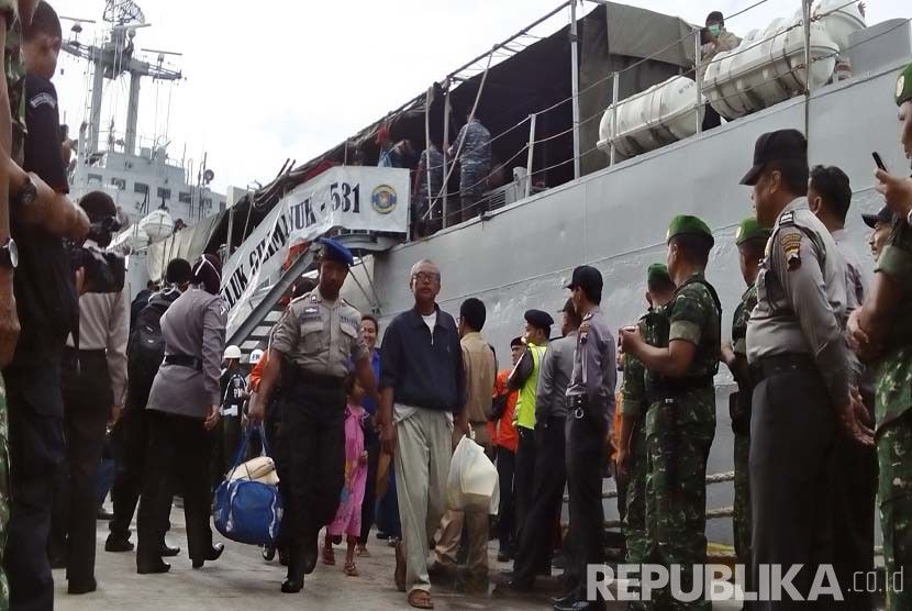 Sejumlah warga eks anggota Gafatar menuruni tangga KRI Gili Manuk beberapa saat setelah tiba di Pelabuhan Tanjung Emas Semarang, Senin (25/1). (Republika/Bowo Pribadi)