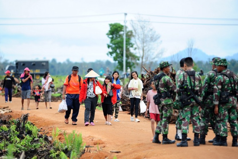 Sejumlah warga eks Gafatar berjalan membawa tas di pemukiman mereka di kawasan Monton Panjang, Dusun Pangsuma, Desa Antibar, Mempawah Timur, Kabupaten Mempawah, Kalbar, Selasa (19/1).