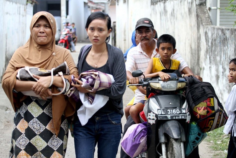 Sejumlah warga Kampung Jawa Lama berlarian keluar rumah menyelamatkan diri setlah mendengar isu tsunami pasca gempa melanda Lhokseumawe, Provinsi NAD, Rabu (11/4).