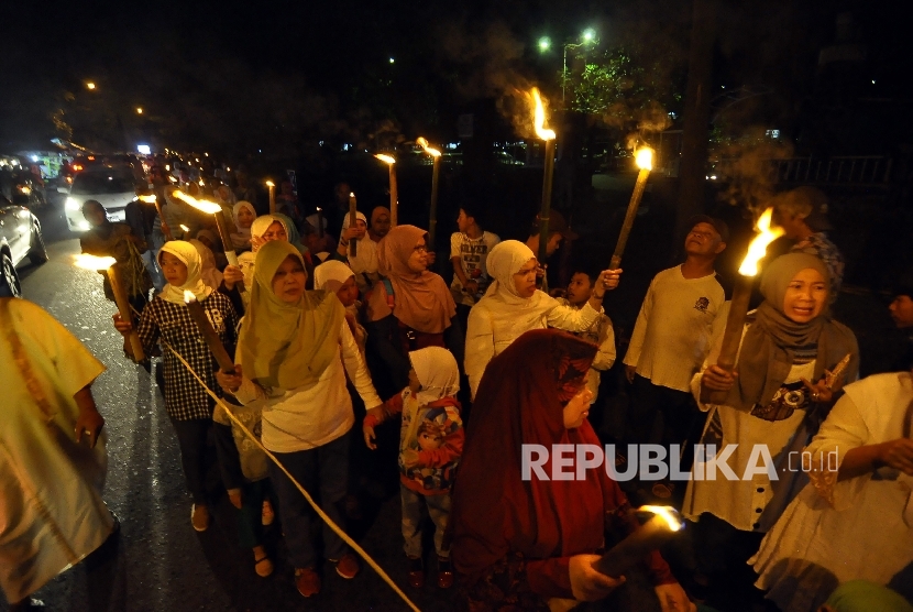 Sejumlah warga Kelurahan Taman sari berjalan membawa obor saat malam 1 Muharam di Jalan Ganesha, Kota Bandung, Sabtu (1/10) malam.