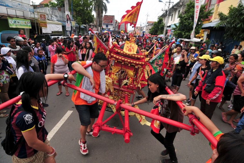 Sejumlah warga keturunan Tionghoa memanggul sambil menggoyangkan tandu berisi kimsin (patung dewa berbadan emas) saat kirab Cap Go Meh di Tegal, Jawa Tengah, beberapa waktu lalu.