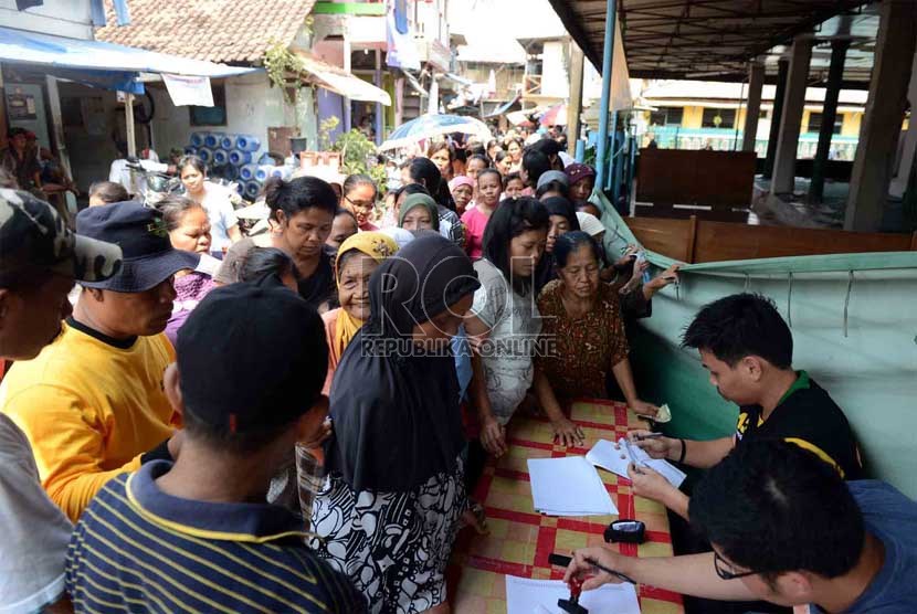   Sejumlah warga kurang mampu antre untuk mendapatkan kupon penukaran sembako murah di Pademangan Jakarta Utara, Kamis (1/8).     (Republika/Agung Supriyanto)