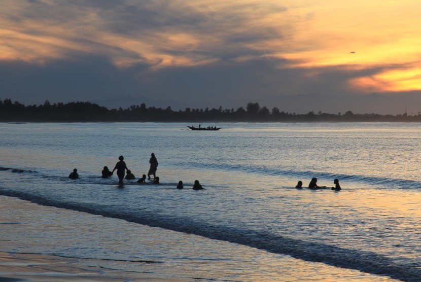 Sejumlah warga mandi sambil menikmati suasana matahari terbit awal tahun 2019 di kawasan objek wisata pantai Desa Gampong Teungoh, Samatiga, Aceh Barat, Aceh, Selasa (1/1/2019). 