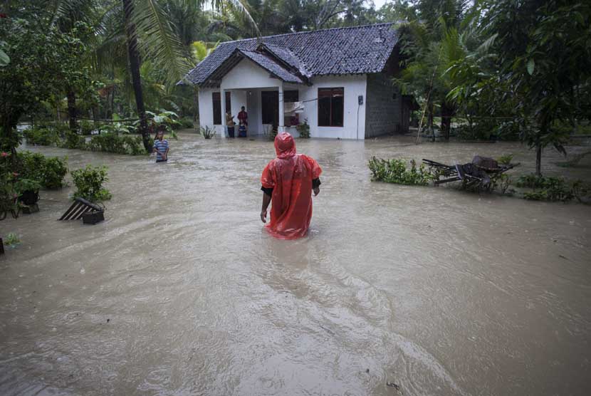   Sejumlah warga melakukan aktivitas ketika banjir menggenangi pemukiman di Desa Gotakan, Panjatan, Kulon Progo, Yogyakarta, Jumat (20/12).   (Antara/Sigid Kurniawan)