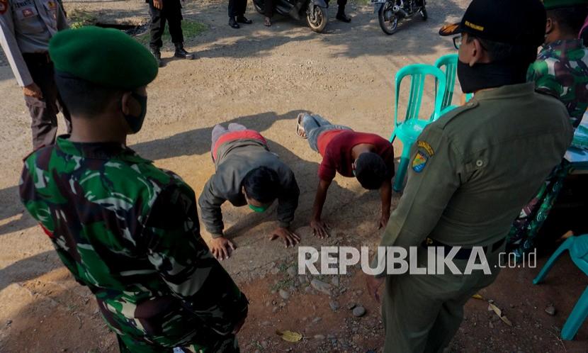 Sejumlah warga melakukan push up saat terjaring razia protokol kesehatan. Warga Kota Palu, Sulawesi Tengah, yang terjaring operasi penerapan disiplin dan penegakan hukum protokol kesehatan diberikan sanksi kerja sosial.