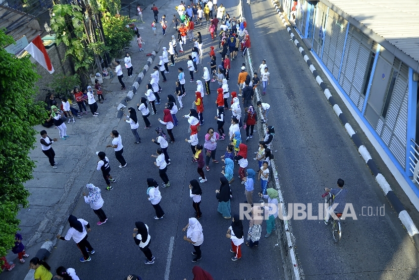   Sejumlah warga melakukan senam pagi di area Hari Bebas Kendaraan Bermotor Mampang-Pejaten (BHKB), Jakarta, Ahad (27/8).