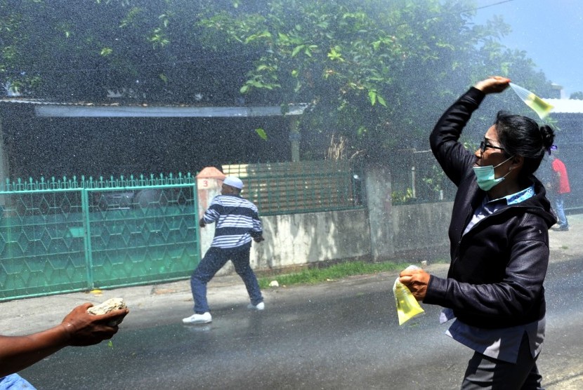 Sejumlah warga melemparkan bensin ke arah polisi saat terjadi bentrokan eksekusi rumah dinas TNI di Kompleks Buntu Torpedo Makassar, Sulawesi Selatan, Kamis (3/12).  (Antara/Yusran Uccang)