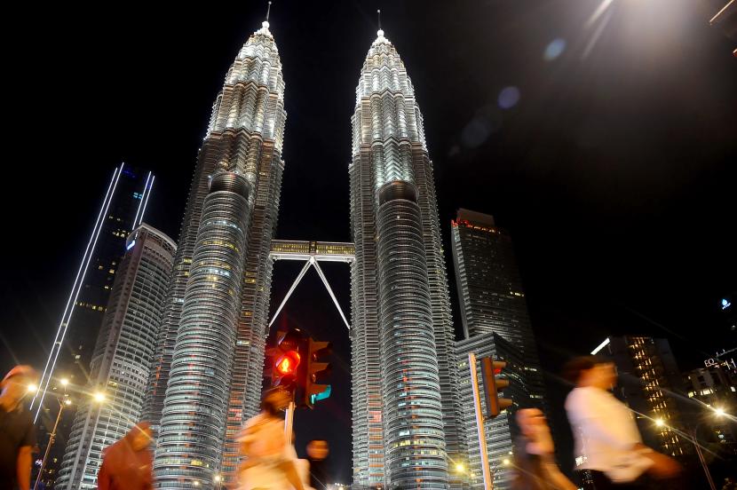 Sejumlah warga melewati menara kembar Petronas (KLCC) di Kuala Lumpur, Malaysia, (ilustrasi)