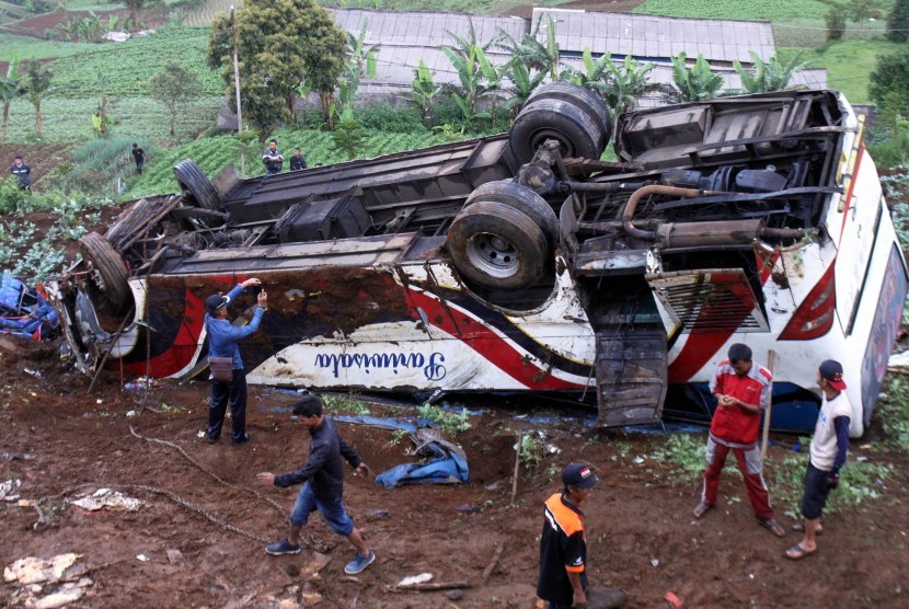 Sejumlah warga melihat bus yang jatuh akibat terlibat kecelakaan beruntun di Jalan Puncak, Ciloto, Cipanas, Cianjur, Jawa Barat, Minggu (30/4).