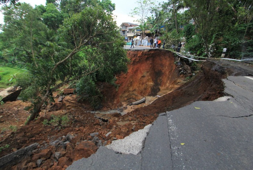 Sejumlah warga melihat jalan penghubung Kuningan-Majalengka yang amblas di desa Kawahmanuk, Kecamatan Darma, Kuningan, Jawa Barat, Jumat (17/2). 