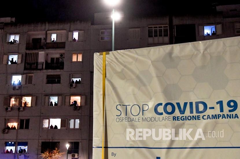 Sejumlah warga melihat konvoi truk pembawa rumah sakit modular untuk orang-orang yang terkena virus Corona saat tiba di Ospedale del Mare, Naples, Italia, Senin (6/4). Negara-negara Eropa tengah melatih pasukan medis guna mengantisipasi datangnya gelombang kedua Covid-19. 