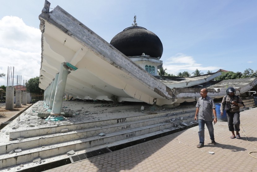 Sejumlah warga melihat masjid yang runtuh akibat gempa 6.5 SR, di Meuredu, Pidie Jaya, Aceh, Rabu (7/12). 