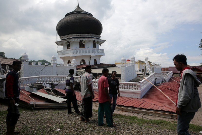 Sejumlah warga melihat masjid yang runtuh akibat gempa 6.5 SR, di Meuredu, Pidie Jaya, Aceh, Rabu (7/12).