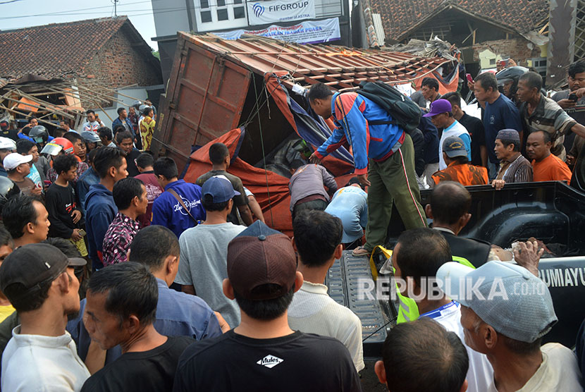 Sejumlah warga melihat truk yang mengalami kecelakaan di jalur tengah Tegal-Purwokerto, Desa Jatisawit, Bumiayu, Brebes, Jawa Tengah, Minggu (20/5).