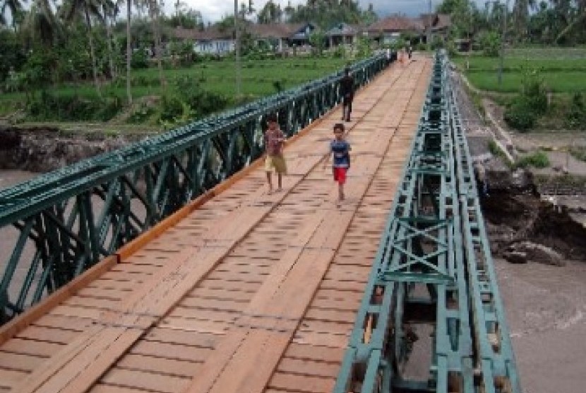 Sejumlah warga melintas di atas jembatan Balley (darurat) yang belum selesai pembangunannya di atas sungai Pabelan desa Adikarto, Mungkid, Magelang, Jateng, Kamis (23/12).