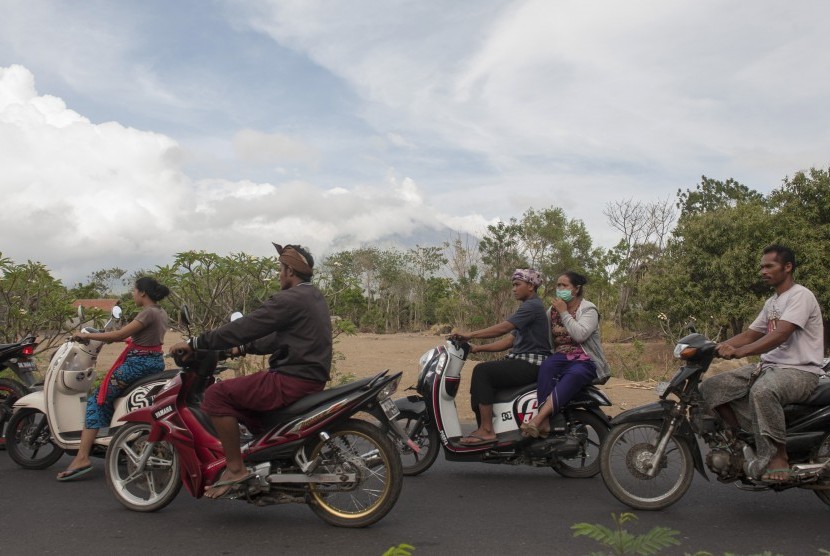 Sejumlah warga melintas di jalan Desa Datah yang berjarak sekitar 10Km dari kawah Gunung Agung, Karangasem, Bali, Minggu (8/10).