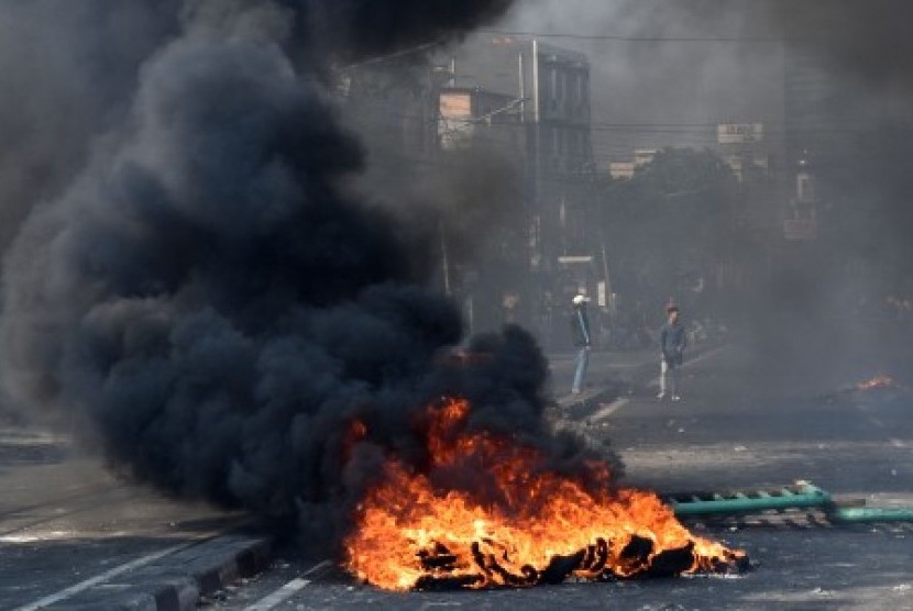 Sejumlah warga melintasi ban yang dibakar di tengah Jalan KS. Tubun, Petamburan, Jakarta Pusat, Rabu (22/5/2019). 