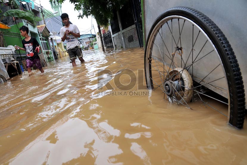   Sejumlah warga melintasi banjir di Jalan Kampung Melayu Kecil,Jakarta Timur, Selasa ( 5/3).  (Republika/Prayogi)