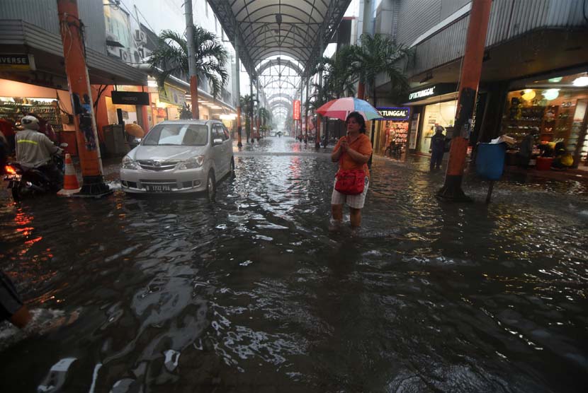 Sejumlah warga melintasi banjir di kawasan Pasar Baru, Jakarta, Senin (9/2).(ANTARA/Zabur Karuru)