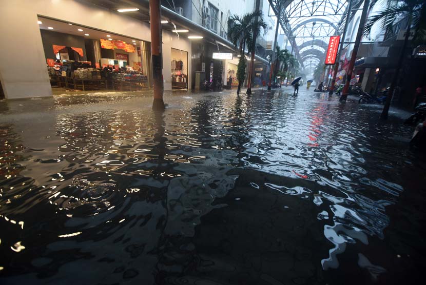 Sejumlah warga melintasi banjir di kawasan Pasar Baru, Jakarta, Senin (9/2).(ANTARA/Zabur Karuru)