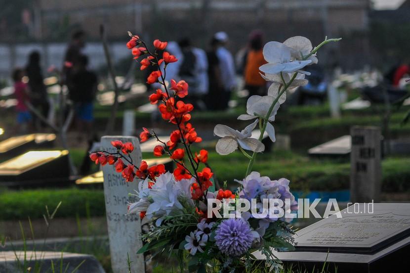 Sejumlah warga melintasi di samping pemakaman khusus COVID-19 TPU Mangunjaya, Tambun, Kabupaten Bekasi, Jawa Barat, Selasa (22/6/2021). Menurut data pengurus TPU Mangunjaya hingga Mei 2021 telah memakamkan 1.023 jenazah kasus postif COVID-19.