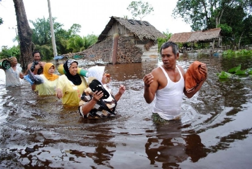   Sejumlah warga melintasi genangan banjir di Desa Pasie Masjid, Kecamatan Merebou, Kabupaten Aceh Barat (ilustrasi).
