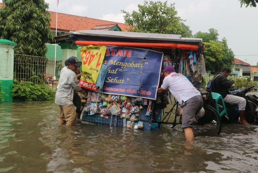 Sejumlah warga melintasi jalan yang terimbas banjir di wilayah Kelurahan Duren Jaya Kecamatan Bekasi Timur Kota Bekasi, Kamis (15/2).