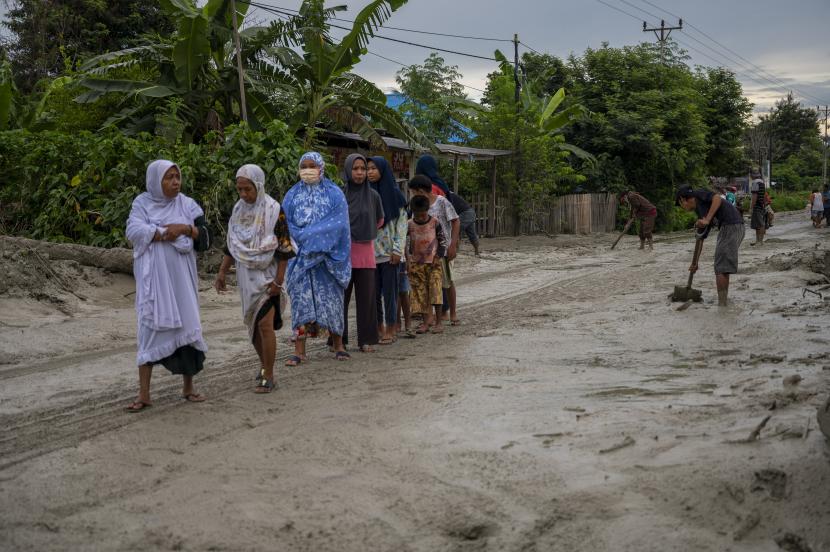 Sejumlah warga melintasi jalan yang tertutup lumpur di Desa Beka, Marawola, Kabupaten Sigi, Sulawesi Tengah, Selasa (11/5/2021). (Ilustrasi)