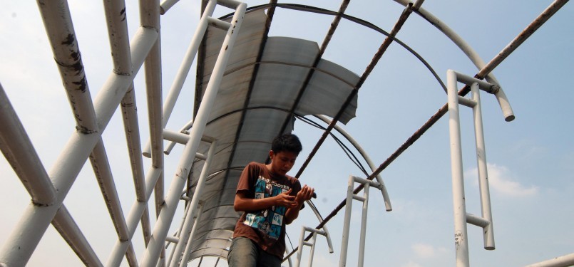 Sejumlah warga melintasi jembatan penyebrangan orang (JPO) tanpa atap di Jakarta, Sabtu (31/3). (Republika/Agung Fatma Putra)