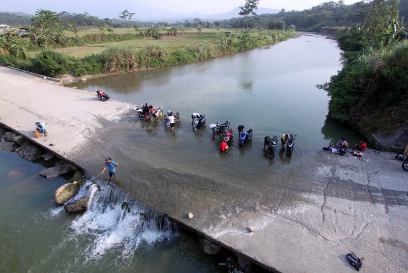 Sejumlah warga memanfaatkan aliran Sungai Cileungsi untuk mencuci pakaian dan mandi di Desa Gunung Sari, Citeureup, Kabupaten Bogor, Jawa Barat, Senin (18/9).