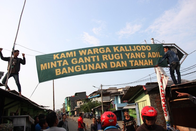 Sejumlah warga memasang spanduk yang bertuliskan tuntutan ganti rugi atas penertiban permukiman di Kalijodo, Jakarta Utara, Kamis (18/2). 