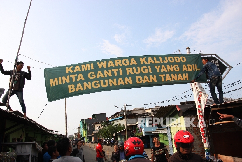 Sejumlah warga memasang spanduk yang bertuliskan tuntutan ganti rugi atas penertiban permukiman di Kalijodo, Jakarta Utara, Kamis (18/2).