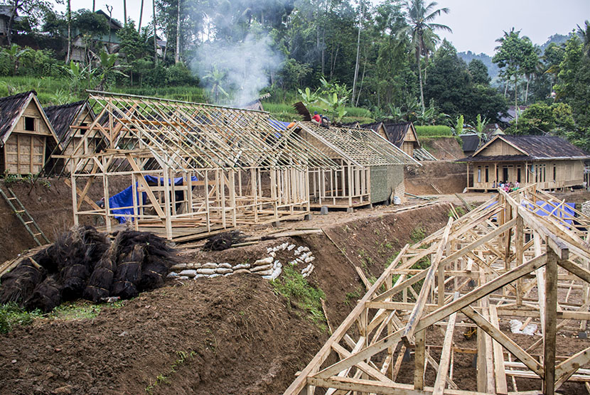 Sejumlah warga membangun kembali rumah adatnya pasca longsor yang terjadi di Kampung Cimapag, Desa Sinarresmi, Cisolok, Kabupaten Sukabumi, Jawa Barat, Rabu (6/3/2019).