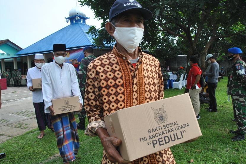 Sejumlah warga membawa bantuan paket sembako yang berasal dari Bakti Sosial TNI AU Peduli di halaman Masjid Jamie Nurul Yaqien, Kampung Sawah RT 05/01 Desa Pabuaran, Kemang, Kabupaten Bogor. (Ilustrasi)